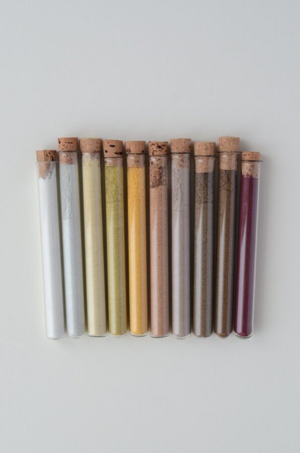 Ten cork-stoppered glass test tubes containing dried and ground kitchen biowaste samples