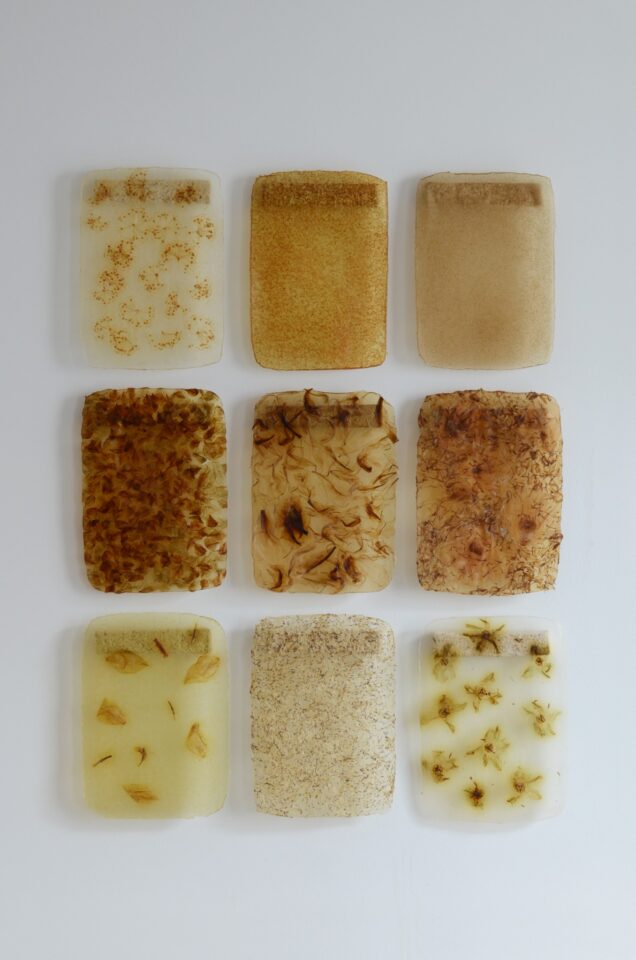 Üheksa eri värvi ja tekstuuriga bioplastiproovi heledal taustal ruudustikuna.